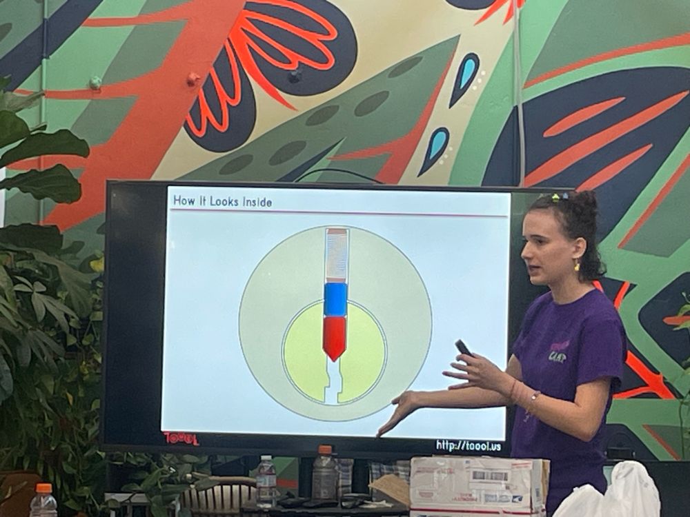 A young woman standing in front of a diagram of a lock