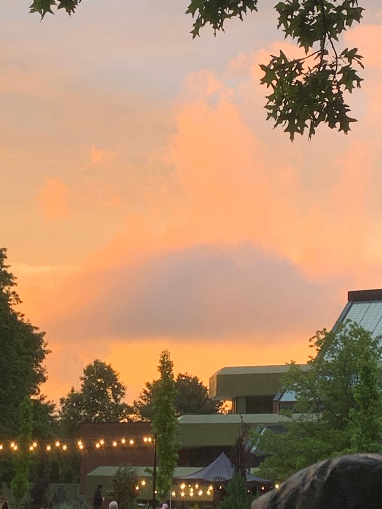 Pink and orange clouds over the brewery and strings of outdoor lights