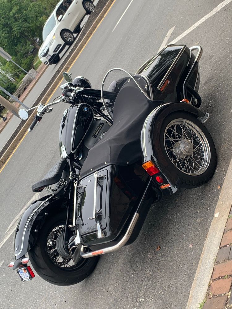 bmw black motorcycle with a sidecar 
the sidecar has a cover