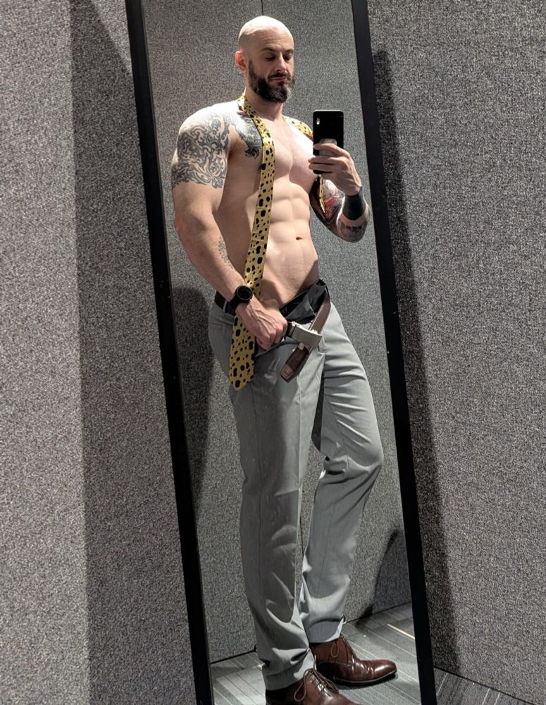 Nanami cosplay. Selfie in the mirror side on. Topless with yellow and black spotted tie around his neck. Belt and trousers undone and being pulled down slightly with left hand. Abs and pecs on show.