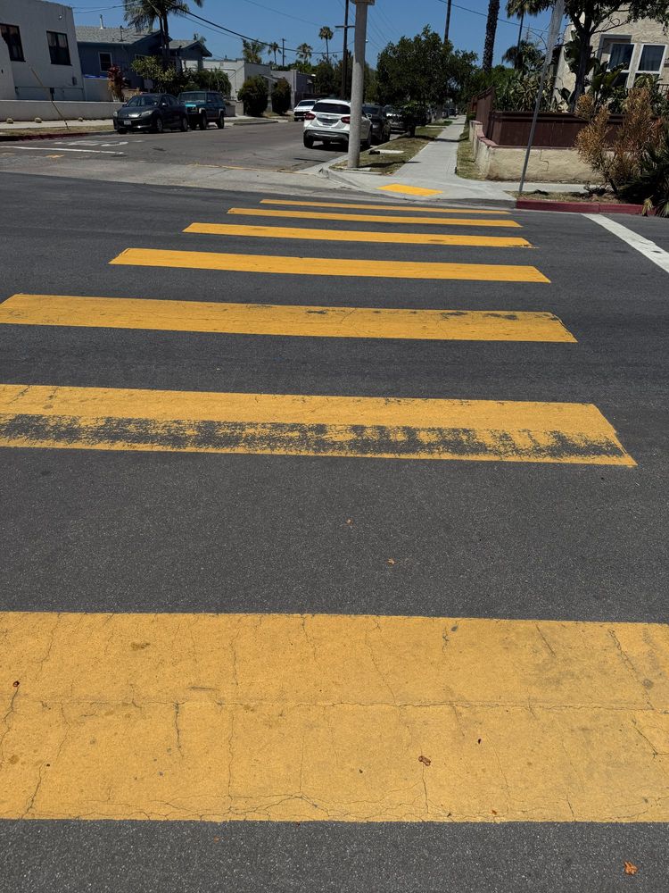 Bold yellow stripes are painted across a street.