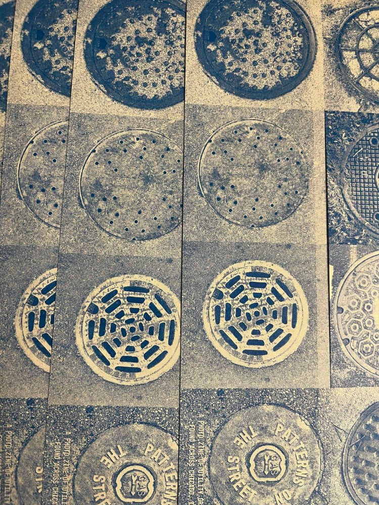 Close up photo of several copies of a math zine. The zine is a photo zine of utility grates