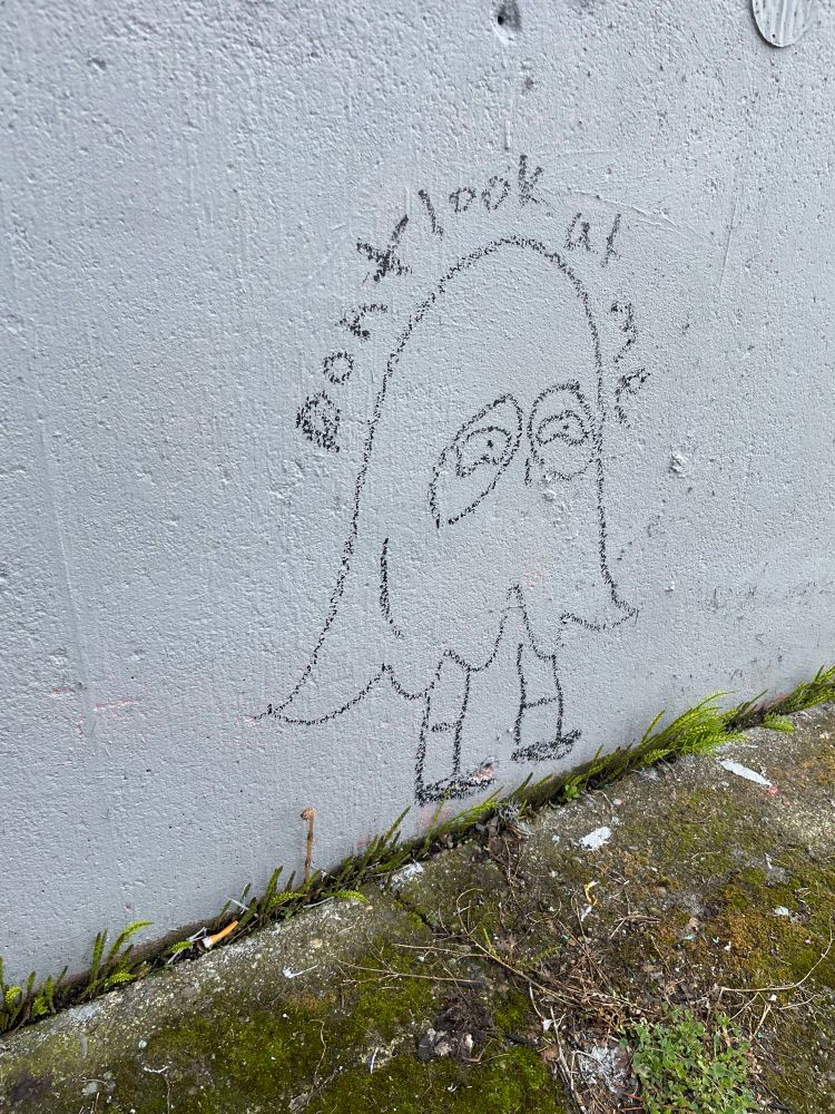 Graffiti of a person dressed as a ghost labeled ‘don’t look at me’
