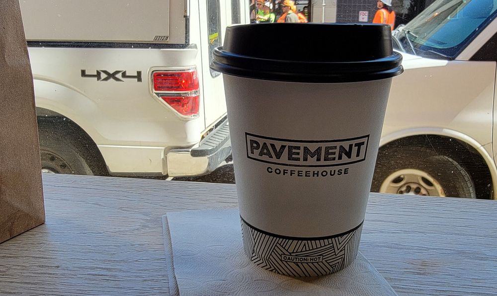 Cafe au lait from Pavement coffeehouse near symphony.  The bag to the left contains a cinnamon raisin bagel. I like the layout inside. There was a constant stream of folks stopping in with fun musical instrument cases.