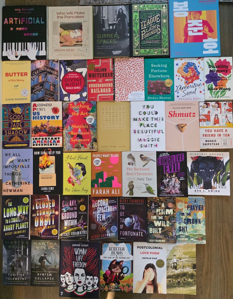 6 Rows of books tiled upon the ground:
Amy Kurzweil - Artificial 
Megan Kelso - Who Will Make the Pancakes
Joanna Moorhead - Surreal Spaces: The life and art of Leonora Carrington 
Lisa Perrin - The League of Lady Poisoners
Karen Han - Bong Joon Ho: Dissident Cinema 
Elaine Khosrova - Butter: A Rich History
Peng Shepherd - The Cartographers 
Natalie Haynes - Divine Might: Goddesses in Greek Myth
Colson Whitehead - The Underground Railroad
Eileen Myles - Inferno: A Poet's Novel
Sindya Bhanoo - Seeking Fortune Elsewhere
Helena Rho - American Seoul
Alice Wong (Editor) - Disability Intimacy:Essays on Love, Care, and Desire
Silvia Moreno-Garcia - Gods of Jade and Shadow
Alexandra Petri: US History, Important American Documents 
Mattilda Bernstein Sycamore - Touching the Art
Victoria Chang - With My Back To The World: Poems
Maggie Smith - You Could Make This Place Beautiful 
Felicia Berliner - Shmutz
Maggie Shipstead - You Have A Friend in 10A
Catherine Newman - We All Want Impossible Things
Laura Sims - How Can I Help You
Pik-Shuen Fung - Ghost Forest
Farah Ali - People Want To Live
Amy Tan - Backyard Bird Chronicles 
Sarah Rees Brennan - Long Live Evil
Eve L. Ewing - Electric Arches 
Becky Chambers - The Long Way to a Small, Angry Planet - A Closed and Common Orbit - The Galaxy, and the Ground Within - Record of a Spaceborn Few - To be Taught if Fortunate - A Psalm for the Wild-built - A Prayer for the Crown-shy
Martha Wells - Fugitive Telemetry - System Collapse 
Marjane Satrapi (Editor) : Woman Life Freedom
Li Chen - Detective Beans & The Case of the Missing Hat
Natalie Diaz - Postcolonial Love Poem
Kate Beaton - Bodies of Art, Bodies of Labor

Books procured from Papercuts, Hummingbird Books, Porter Square Books, Brookline Booksmith, Frugal Books, Grolier Poetry
