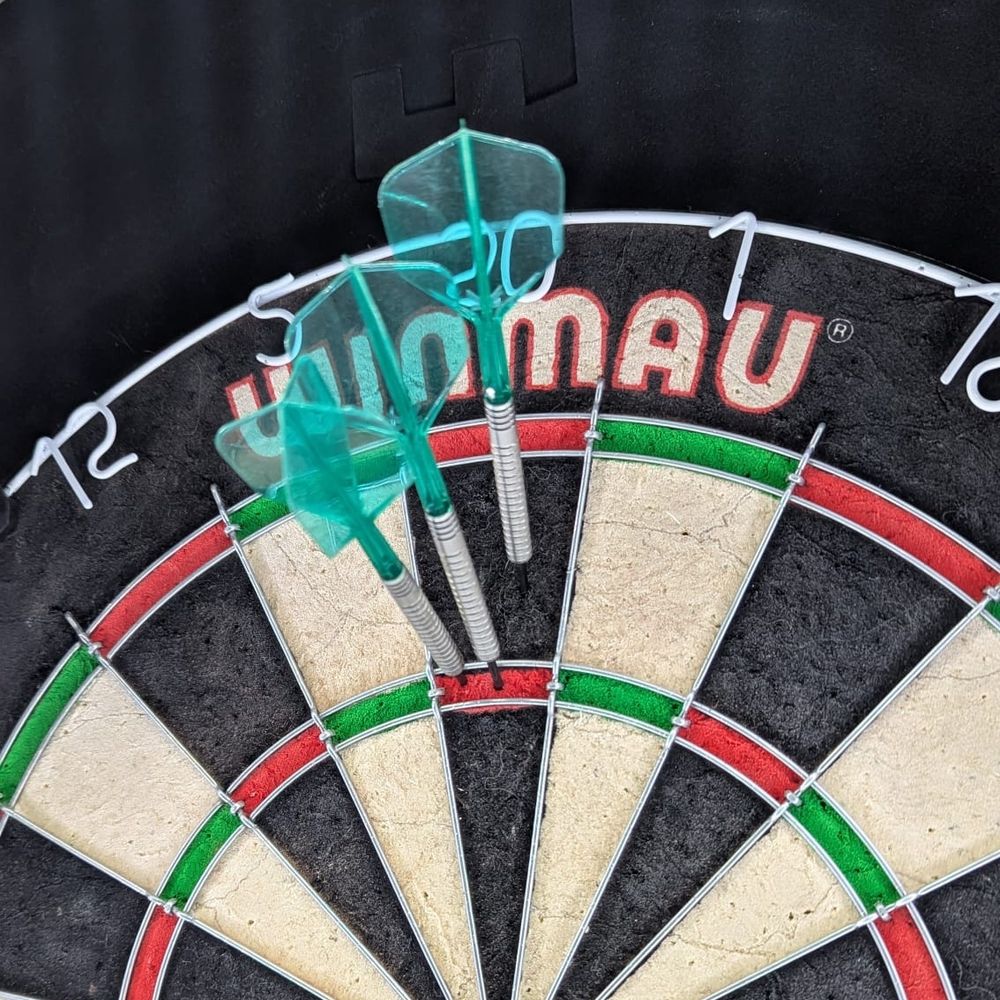 Two darts in treble 20, one in single 20, missing out on a max possible score of 180
