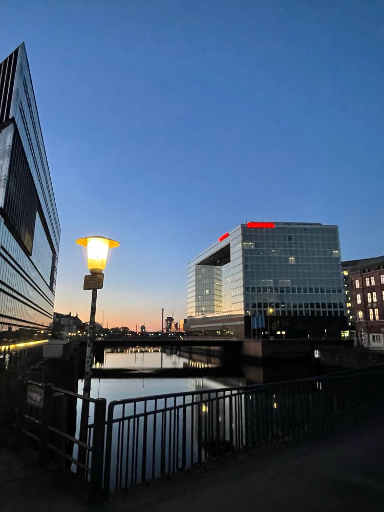 SPIEGEL-Gebäude am frühen Morgen. Sonnenaufgang, Wasser, Laterne. 