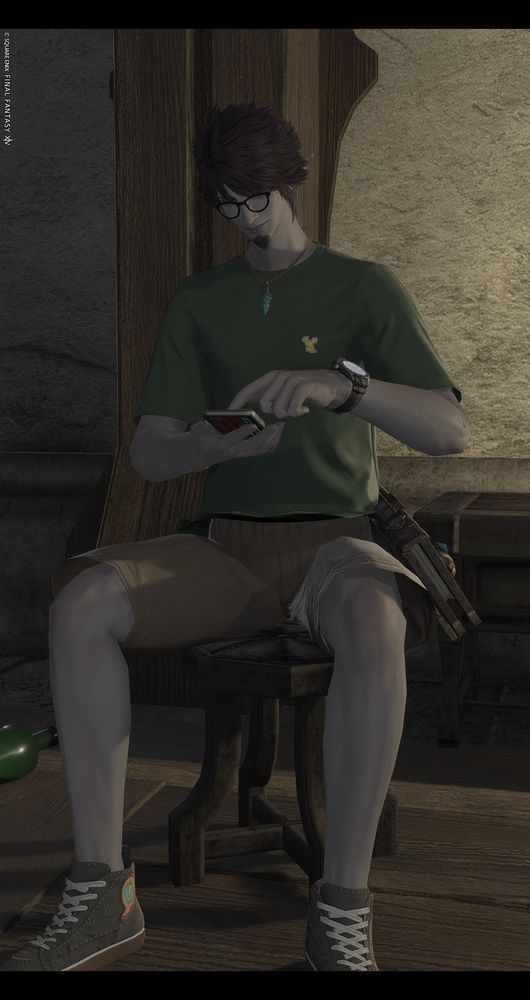 My character, Revenauex Delmore, in FFXIV using a cellphone on a stool wearing a green t-shirt and khakis. 