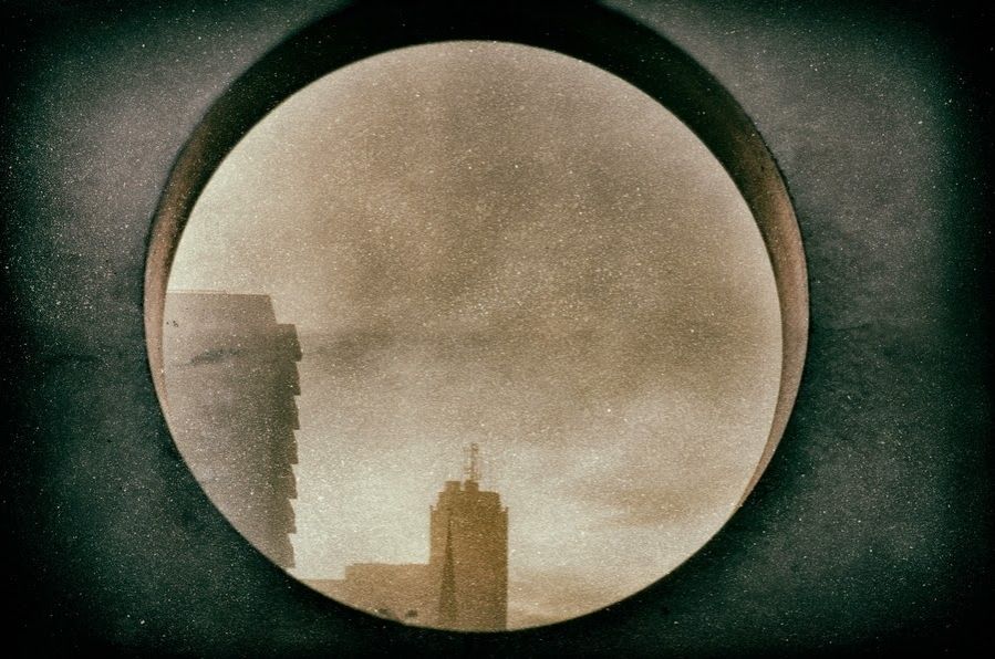 City skyline through concrete opening in wall on roof of building