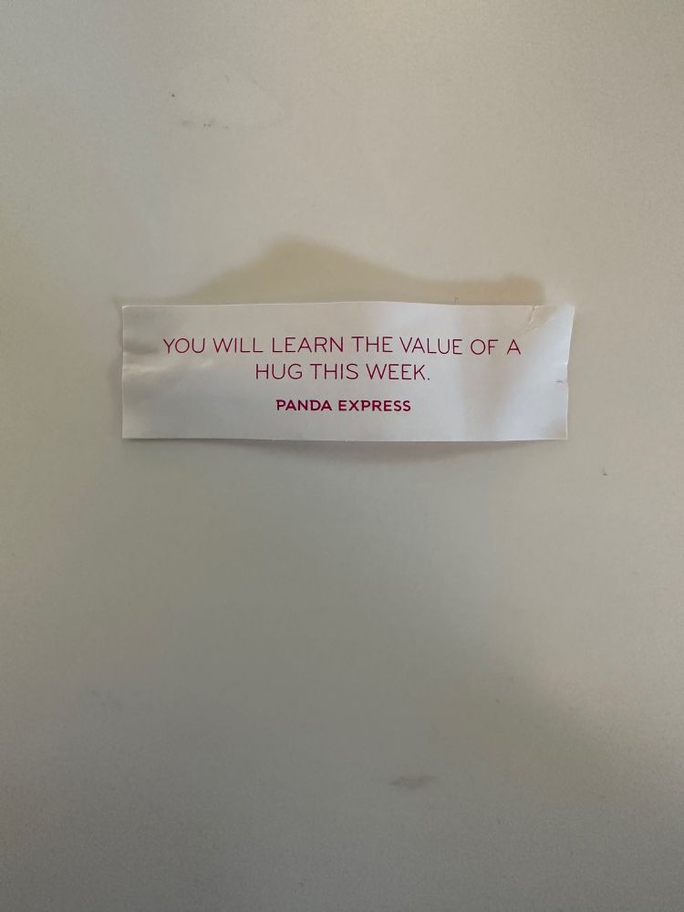 A fortune cookie fortune reading “You will learn the value of a hug this week.”