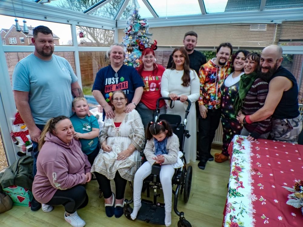 11 adults and 2 children posing for group photo