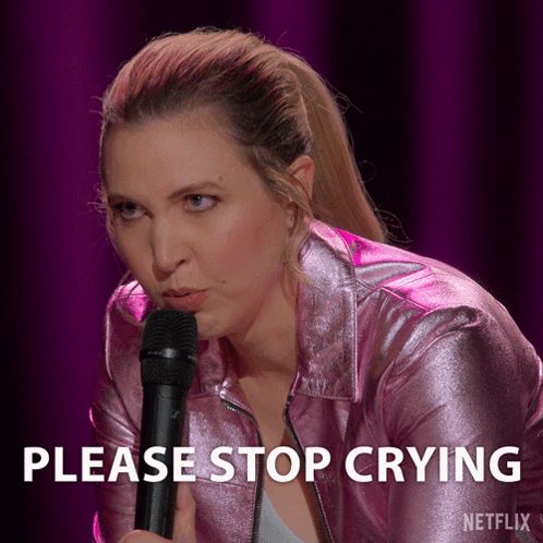 a woman in a pink jacket is holding a microphone with the words please stop crying below her