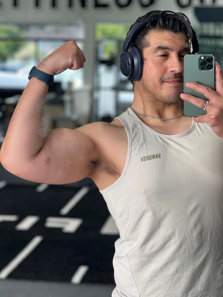 Im flexing my left bicep showing off a hollow blue tattoo heart. 