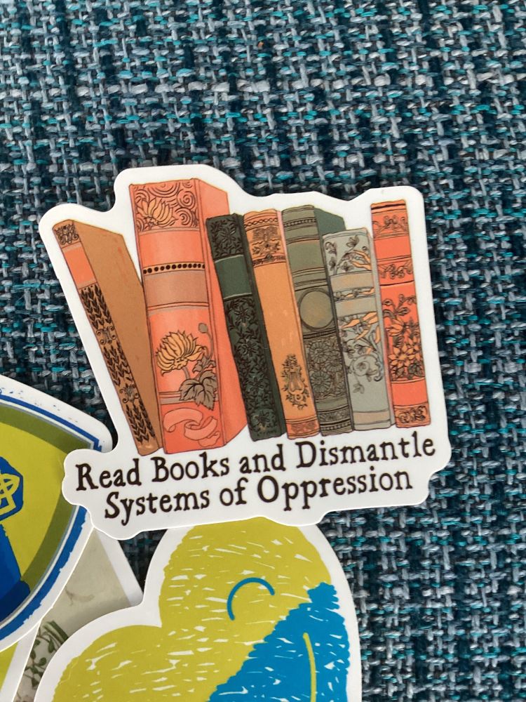 Sticker: read books and dismantle systems of oppression. Also in frame Ukraine supporting 
stickers