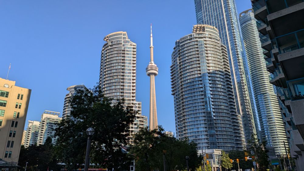 The CN Tower in Toronto between tall condo buildings 