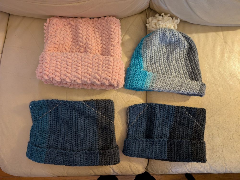 4 hats, 1 pink cat ears, 1 blue/grey with pom pom, 2 blue/grey cat ears. These were made for friends/family