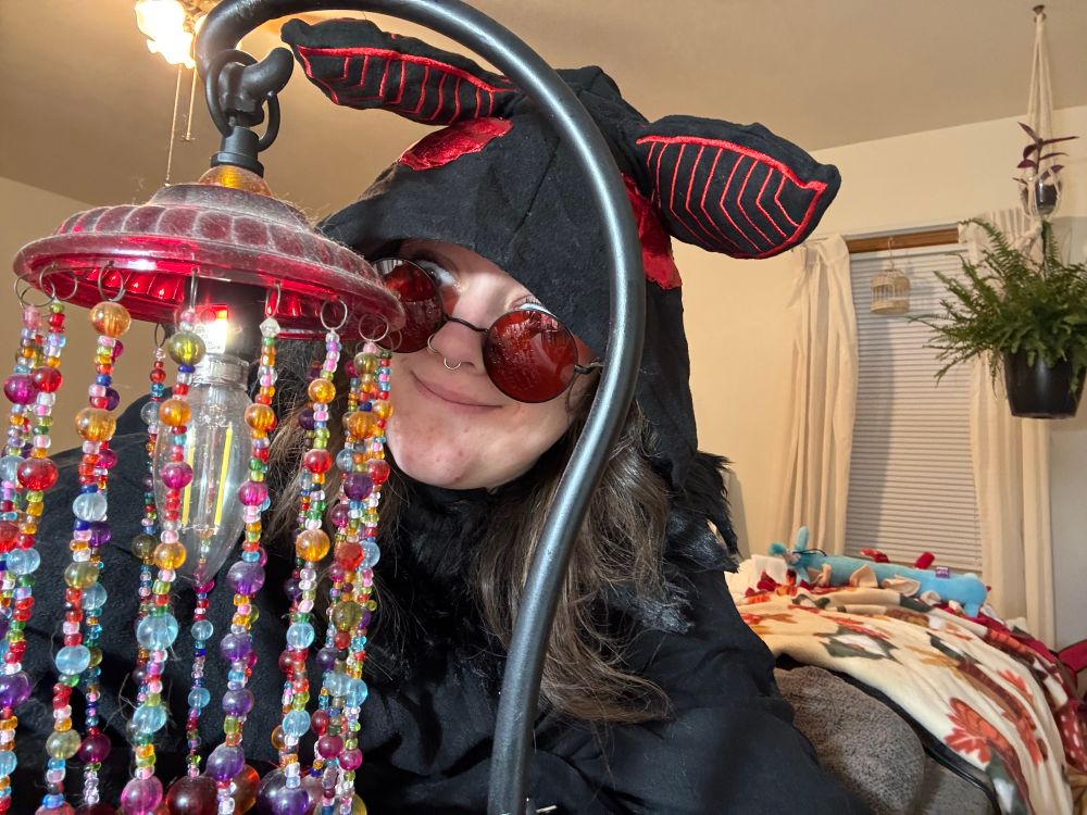 al dressed up as mothman staring at a beaded lamp