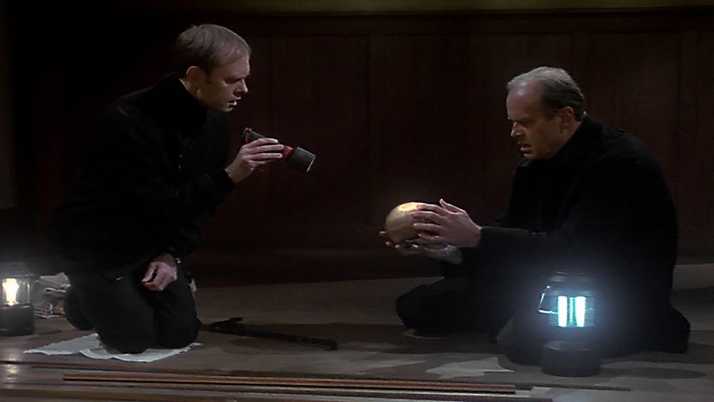 A screenshot from Frasier episode Deathtrap, in which they find a skull under the floorboards of their childhood home