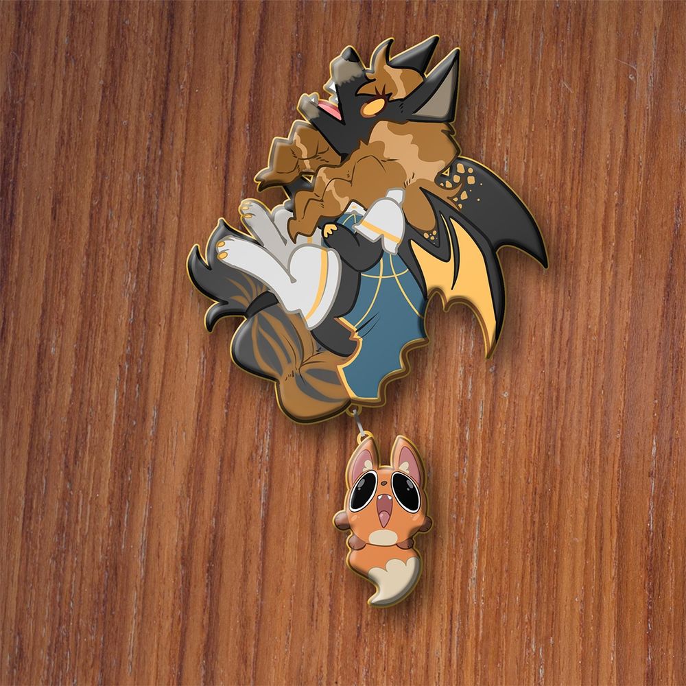 A mockup of an upcoming pin. It features an anthropomorphic fox in a cute style, giving a fox scream to the heavens. She has black fur and orange fur, black and gold wings, and wears fancy blue and white clothes. A second, smaller pin dangles off of her tail, and it is a tiny orb-shaped fox familiar, giving a similar scream of joy.