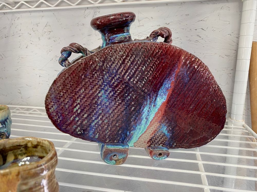 Large vase. Very chunky in design. Many colors but primarily a red with blue and orange highlights.  The design reminded us of old trailers people used to haul behind their cars to go camping.  We bought this one.