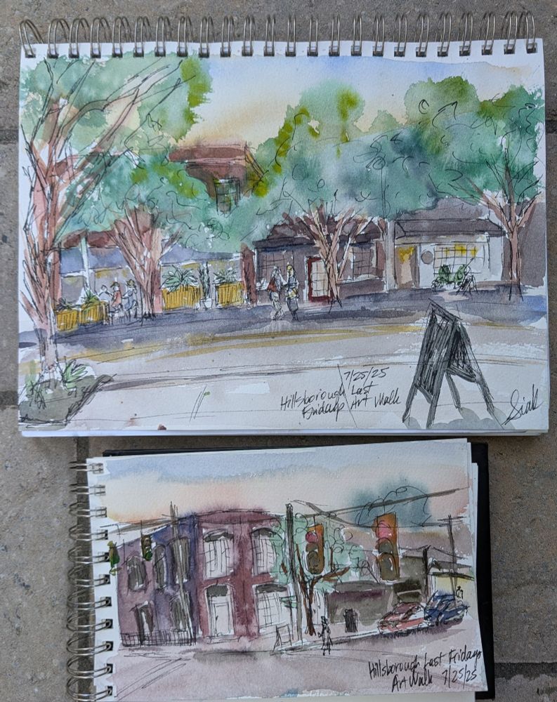 Two sketchbooks showing watercolor and ink sketches of small town street scenes