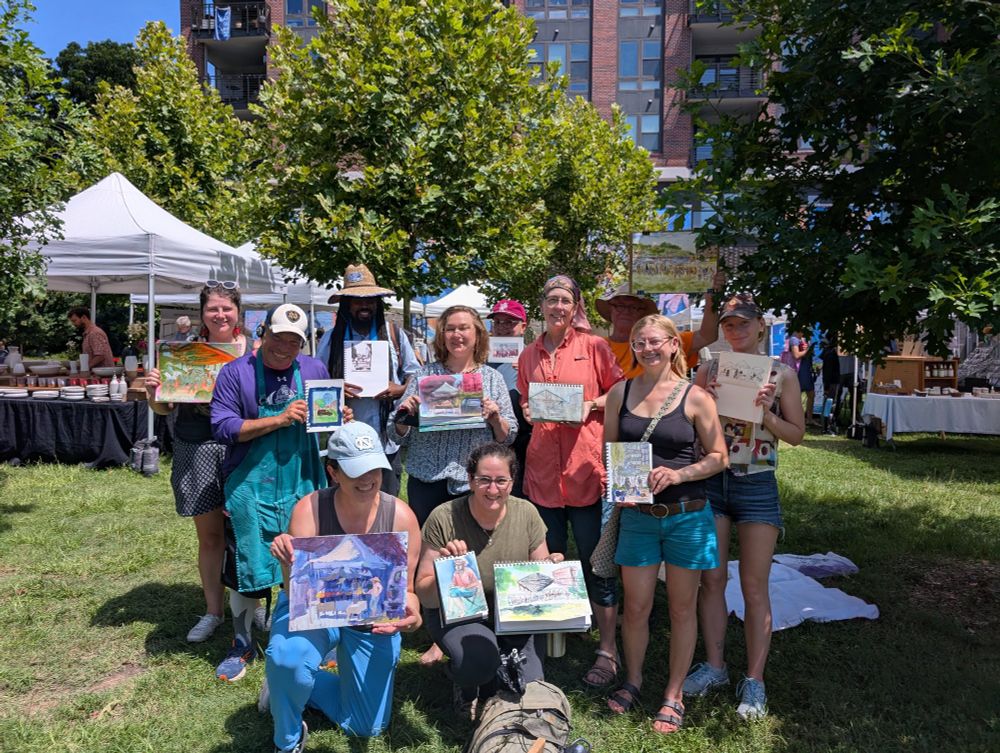 A group of sketchers holding up their work