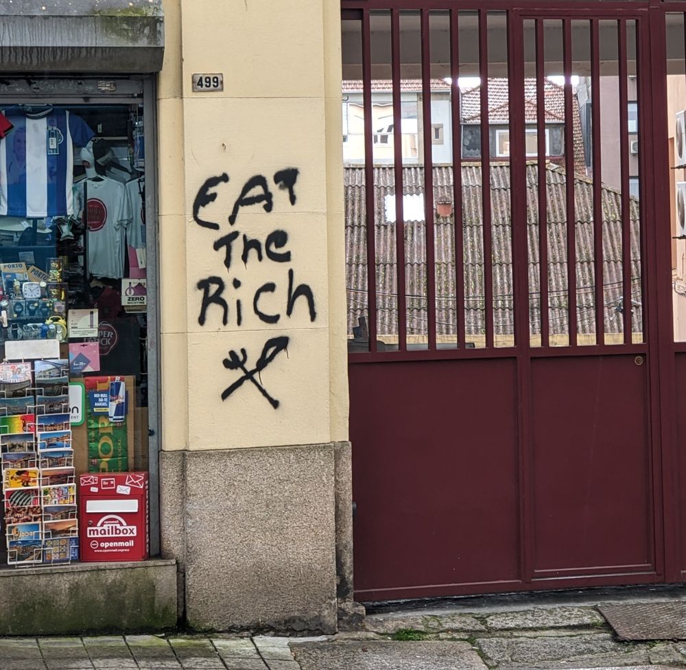 The classic "eat the rich" with a fork and knife crossed below it