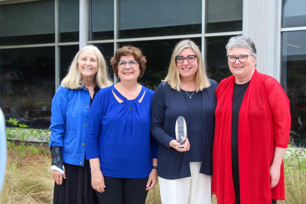 Heidi Hennink-Kaminski holds the Distinguished Scholar Award as other Grady faculty pose with her.