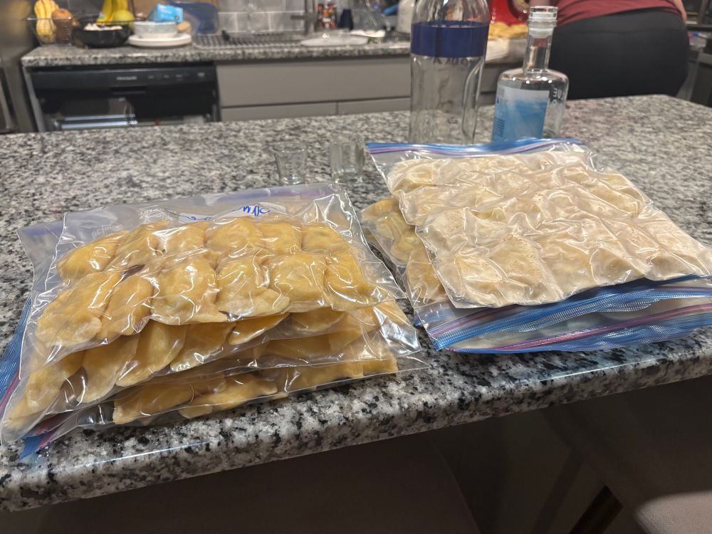 Finished pierogi bagged on the counter with vodka bottles