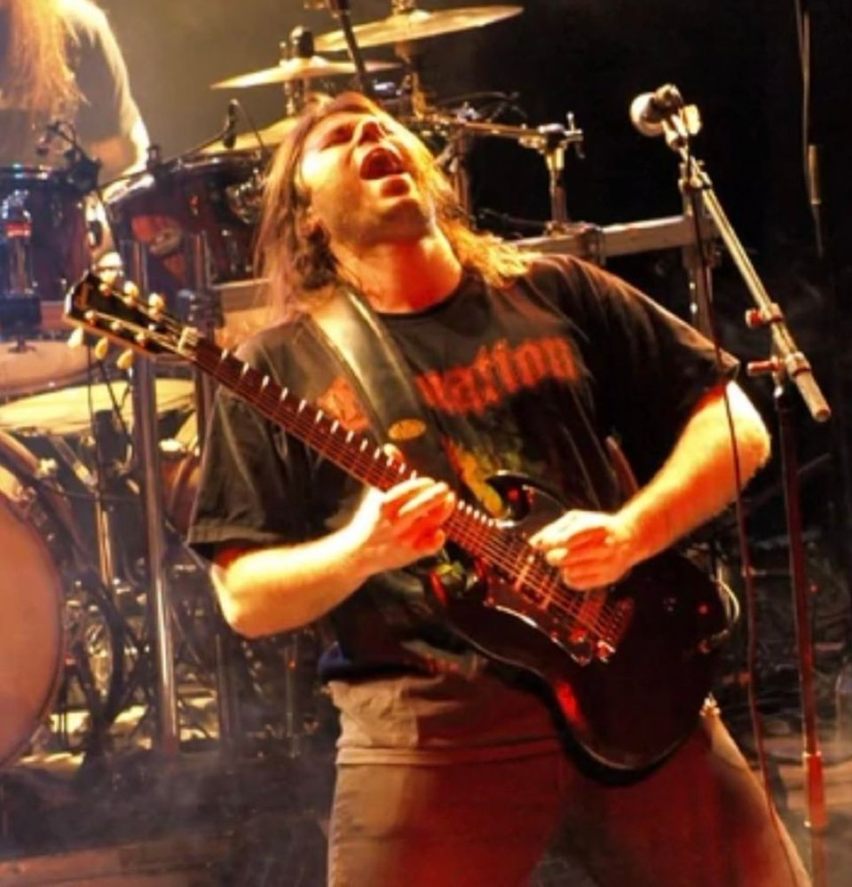 Dan Swanö playing guitar live on stage.