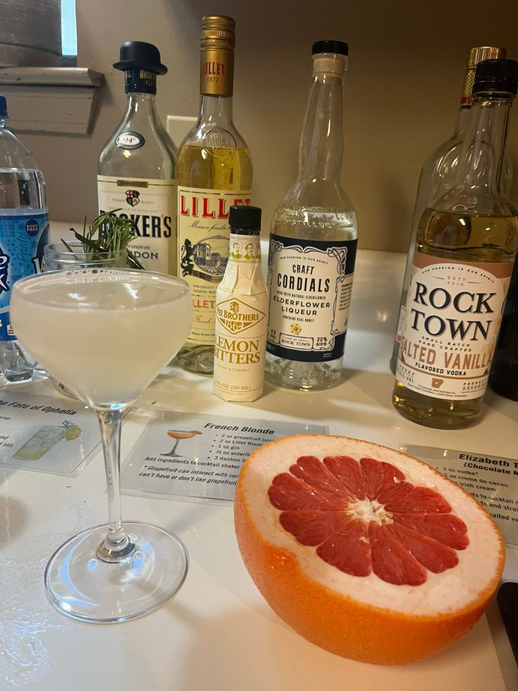 A french blonde cocktail next to half a grapefruit