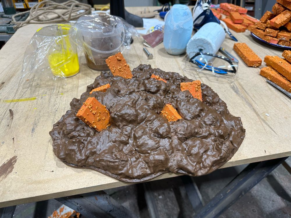 A fake pile of poop with orange fish finger sticking out of it. 