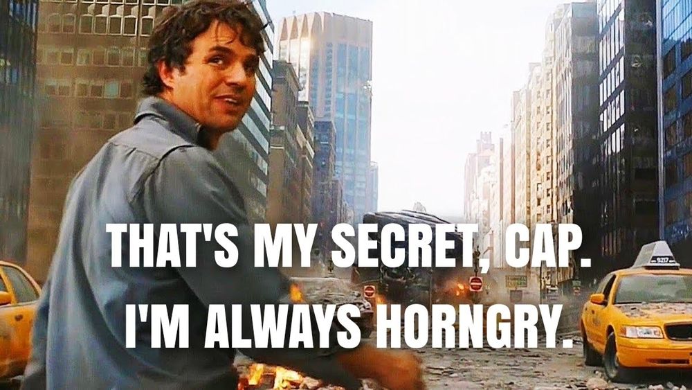 Bruce Banner looks to the camera, with a chaotic battle in the background and says "That's my secret, Cap. I'm always horngry."