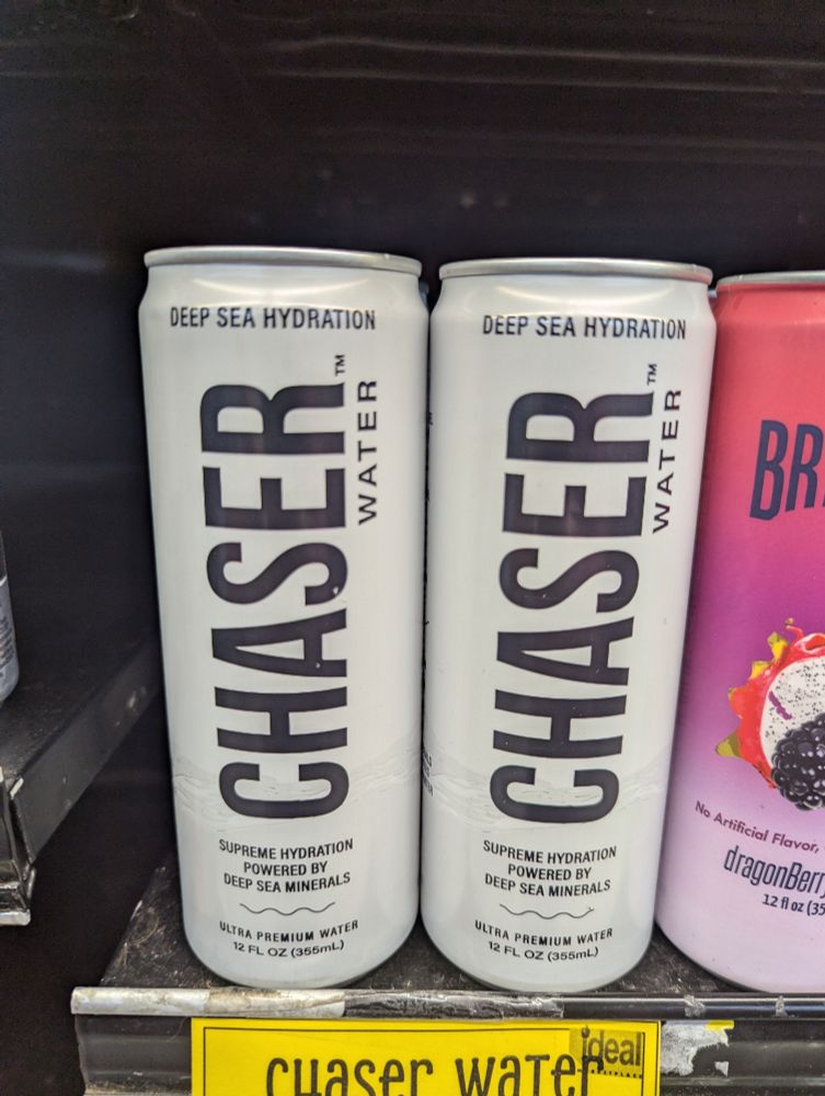 White cans on a supermarket shelf. The label, in black text reads "Chaser Water".

#chaserwater