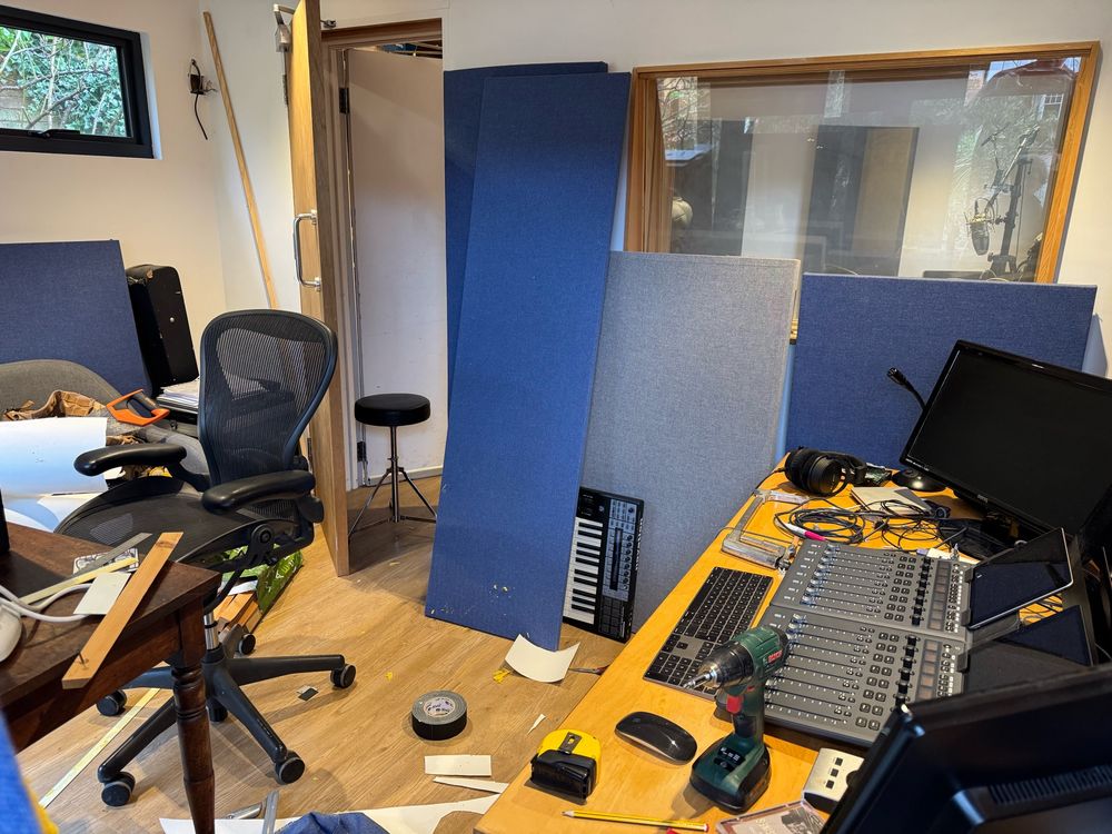A picture of a studio control room with acoustic panels and tools all over the place 