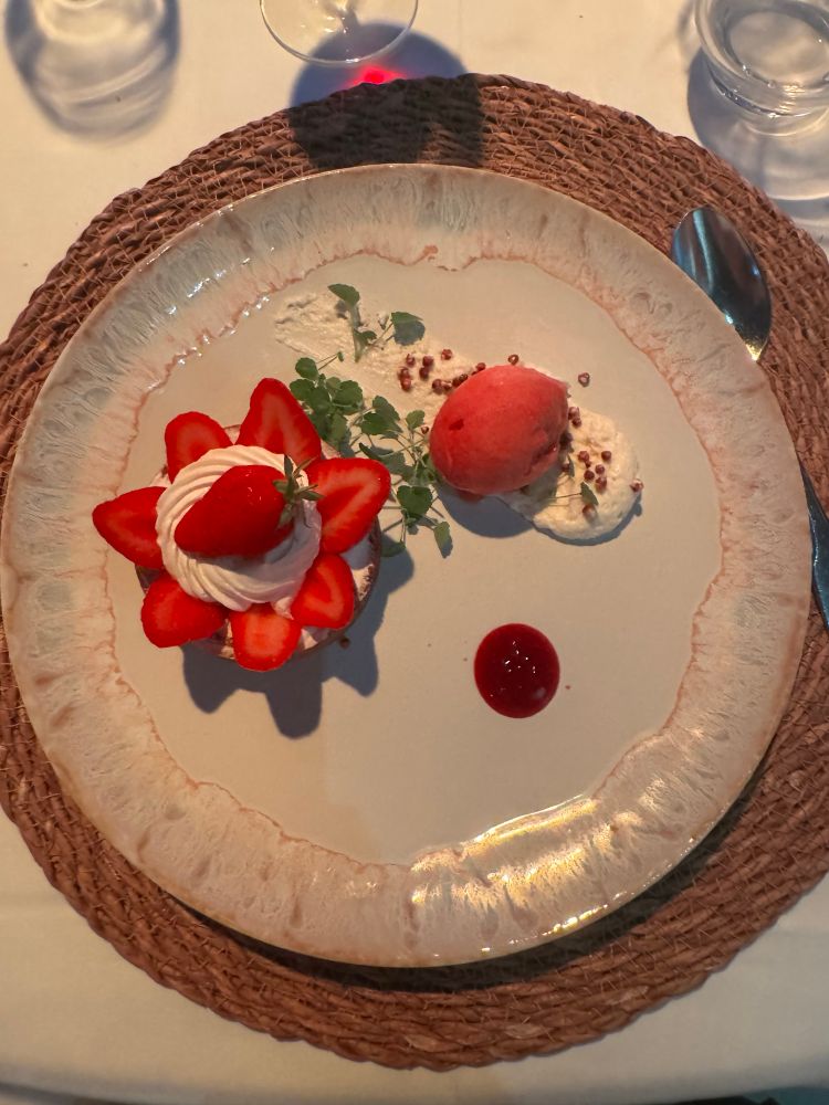 A plate with strawberries and cream desert