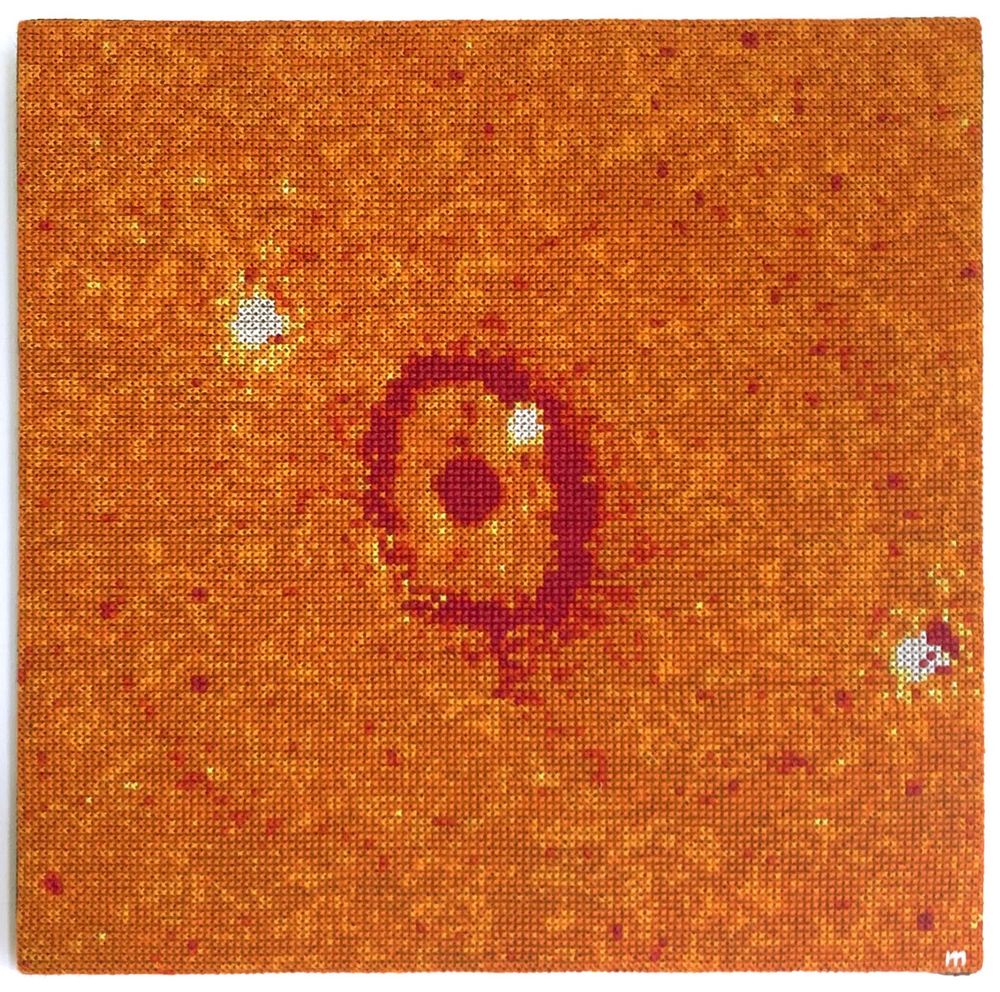 Cross-stitch embroidery representation of SN_1987A supernova. Stitches are in different shades of orange, with a darker circle in the middle of the embroidery.
18 × 18 cm