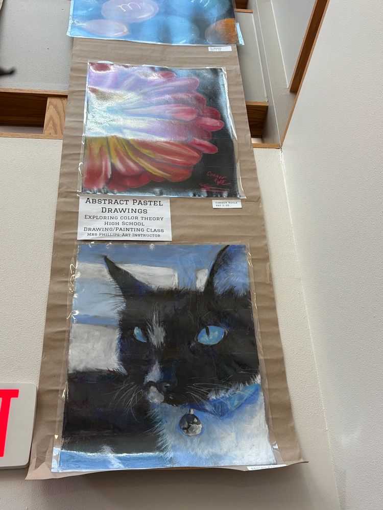 Photo of artwork on a wall, focused on a black cat