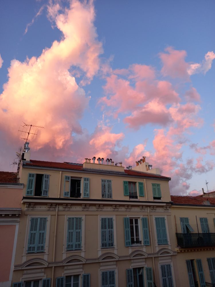 Ciel bleu rempli de nuages roses au dessus de l'immeuble face à mon appartement 
