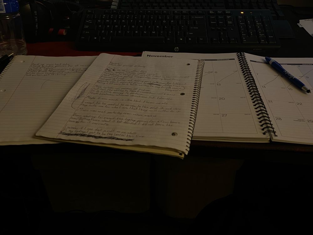Two journals and a calendar, all open and mostly filled with quickly written notes, plans, thoughts, and lists. 