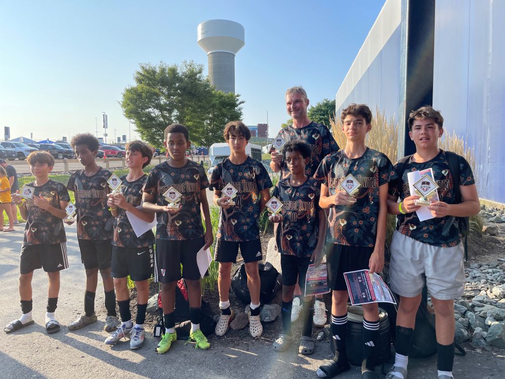 Cambridge United in town U14 boys soccer team holding the Revolution 4v4 August tournament prizes for winning the final. 