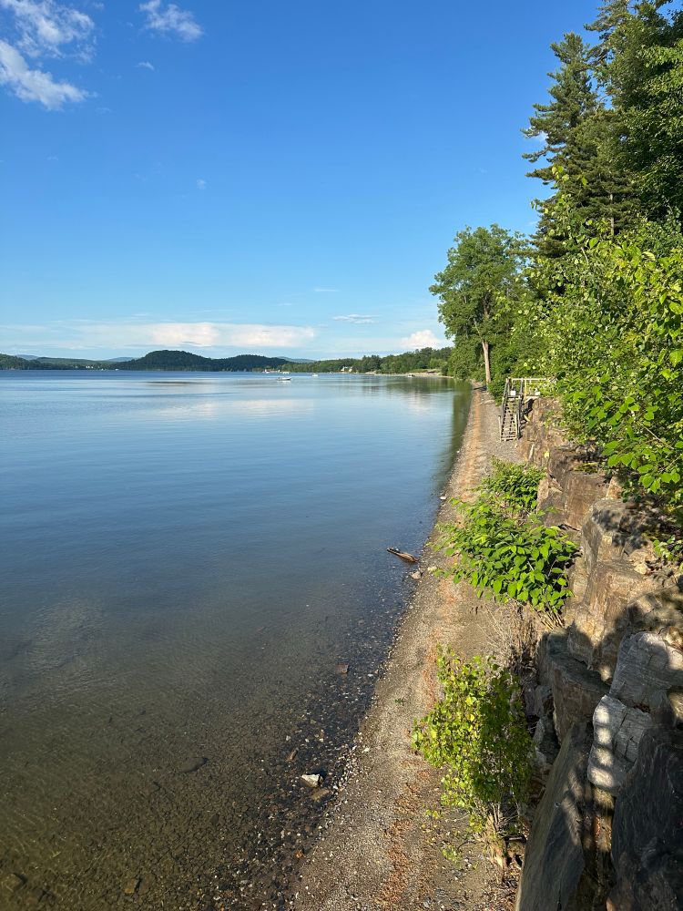 Small lakeshore with shallow water and a bank with stairs 
