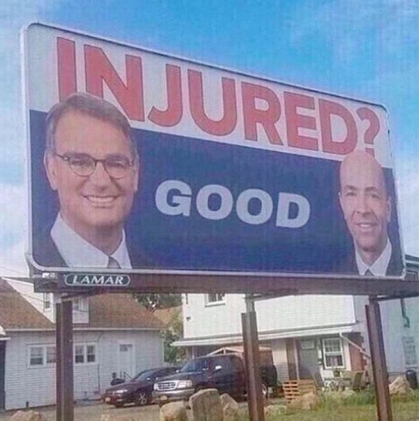 billboard ad with two white lawyer guy faces with the word "INJURED?" in bold red at the top and the word "GOOD" in white on a blue background below
