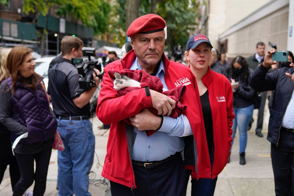 Curtis Sliwa wearing a red jacket and holding a cat
