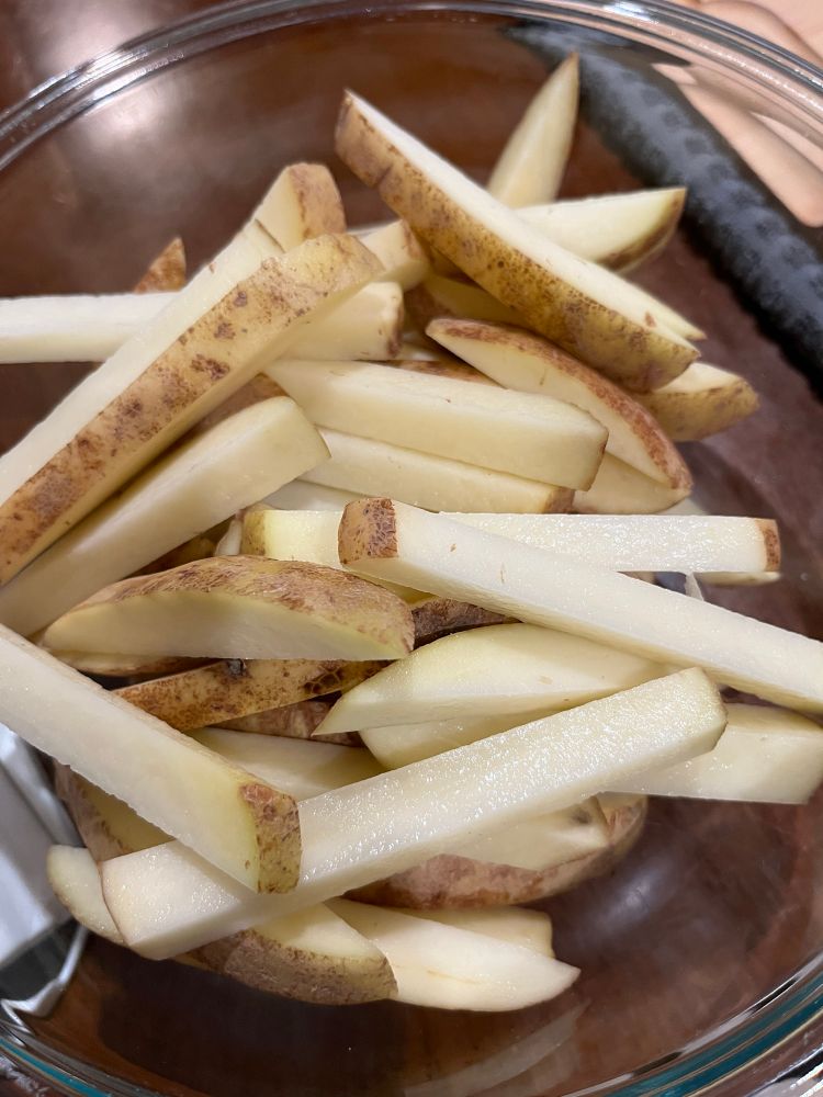 This is the top view of a Pirates bowl. It is filled with potatoes, cut up into french fry shapes.