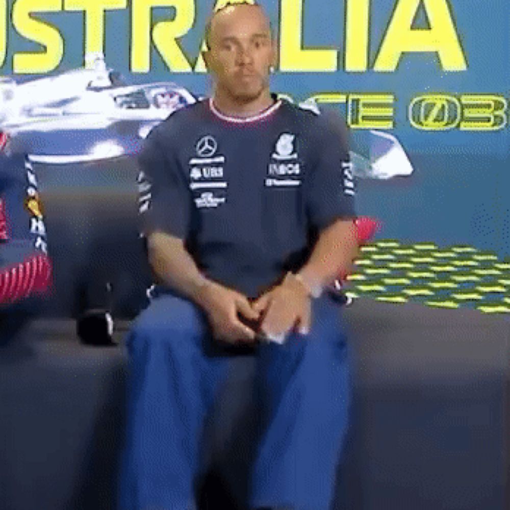 a man sitting in front of a wall that says australia