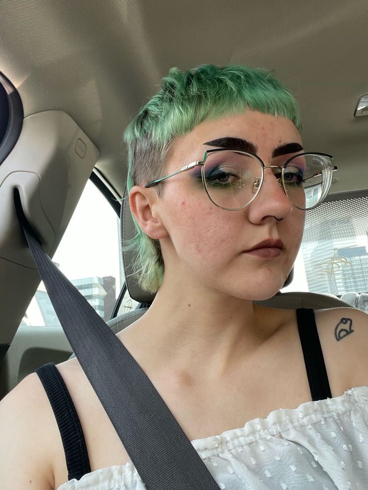 bread selfie in the passenger seat of their gf’s car ! they have a green mullet with shaved sides