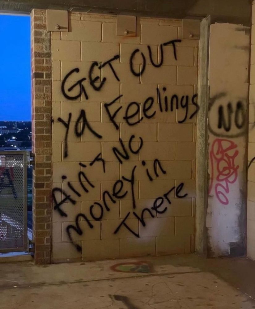 Cement wall spray painted with graffiti that says get out your feelings ain’t no money in there