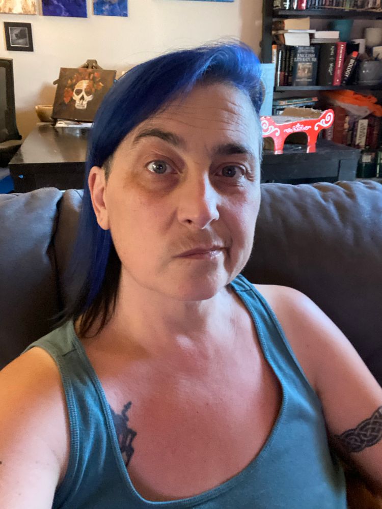 Less round Cris! Green tank, much longer hair (still blue), silly look on face. 