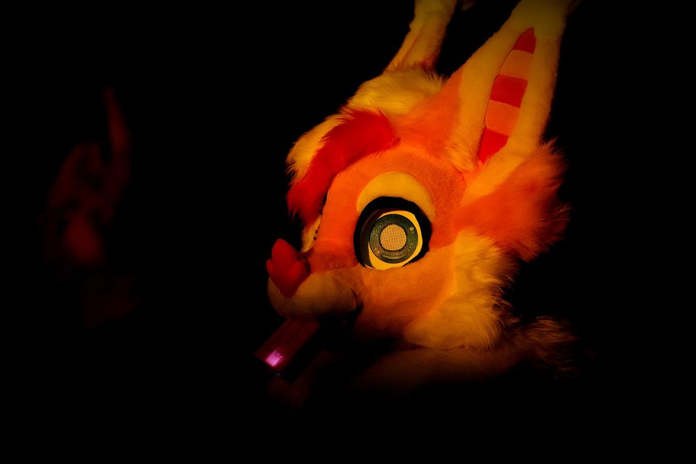 A shot I took from the 2025 Midwest FurFest dance party on Saturday Night, 12/6. It resembles the shot of Daniel Day Lewis in the movie There Will Be Blood when he is looking up at an oil derrick fire at night, highlighting his face in the dark.